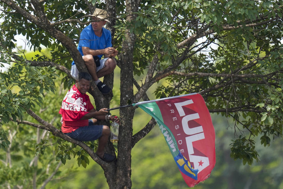 Supporters of Luiz Inacio Lula da Silva wait to see him riding in an open car to Congress for his swearing-in ceremony in Brasilia, Brazil, Sunday, Jan. 1, 2023. (AP Photo/Andre Penner)