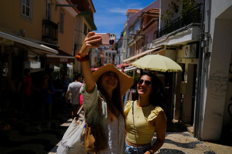 FILE PHOTO: Tourists take a picture on a street in Cascais