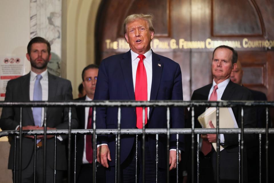 Donald Trump and his legal team, along with his son Eric Trump, left, address reporters during a lunch break in a civil trial on fraud allegations in Manhattan on 17 October. (Getty Images)