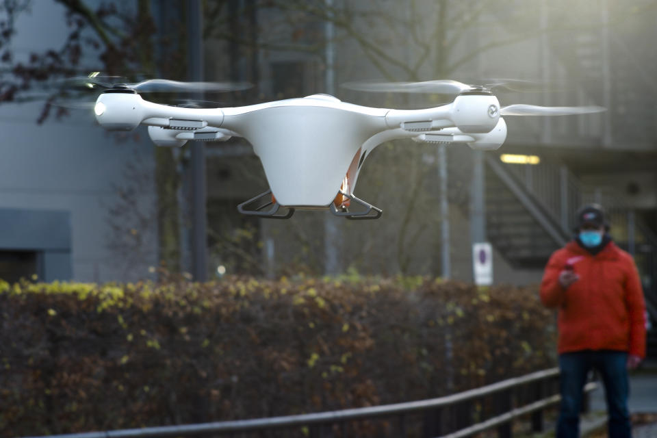 Drone and logistic operator Peter Trempeck monitores the automatic landing of a drone with a case for medical stuff during a presentation for media, near the Labor Berlin laboratory in Berlin, Germany, Monday, Nov. 23, 2020. Each drone can carry about 40 test samples, not only for Corona tests, that need to be examined in a laboratory. (AP Photo/Markus Schreiber)