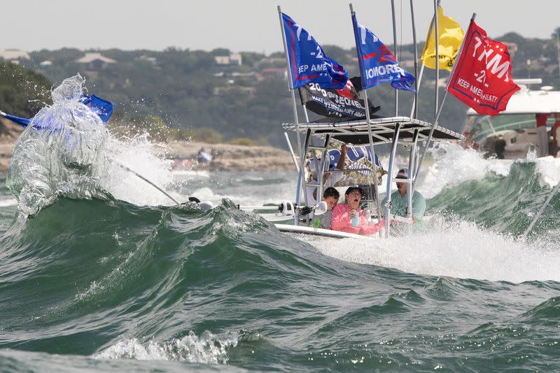 A boat is engulfed in waves from the large wakes of a flotilla of supporters of U.S. President Donald Trump, during a boat parade on Lake Travis