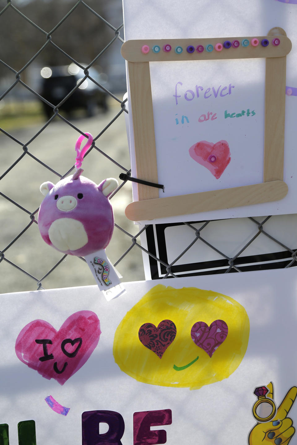 Tributes are hung on a fence in front of the house that was the site of a quadruple homicide in Colts Neck, N.J., Thursday, Nov. 29, 2018. Prosecutors say financial motives led a New Jersey technology executive to kill his brother, the brother's wife and their young children before setting fire to their two homes. (AP Photo/Seth Wenig)