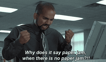 Frustrated man wearing a shirt and tie from "Office Space" saying "Why does it say paper jam when there is no paper jam?!"