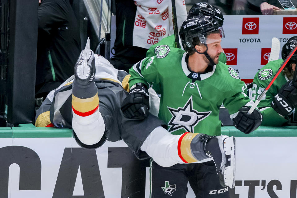 Dallas Stars' Luke Glendening, right, checks Vegas Golden Knights Alex Pietrangelo atop the boards during the first period of Game 4 of the NHL hockey Stanley Cup Western Conference finals Thursday, May 25, 2023, in Dallas. (AP Photo/Gareth Patterson)