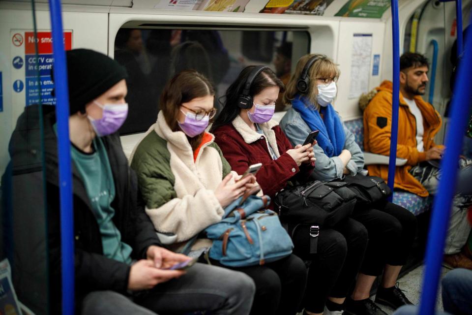 <p>Commuters wear masks on a London Underground Tube train </p> (AFP via Getty Images)