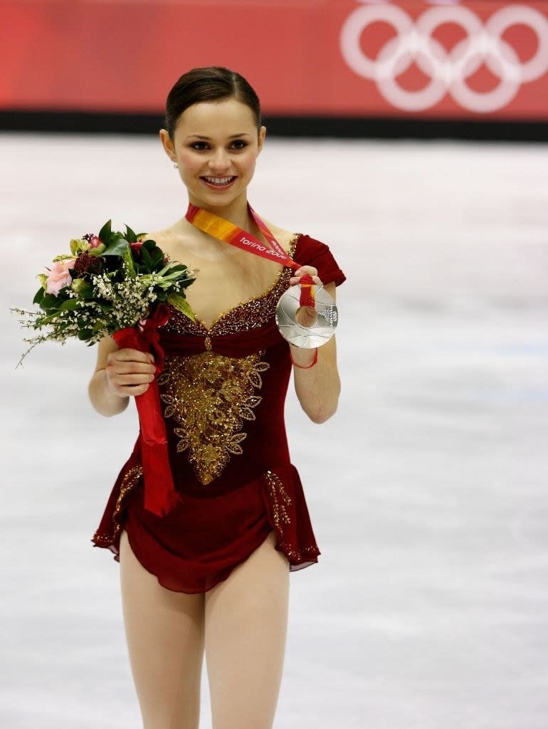 sasha holding up her silver medal and a bouquet of flowers