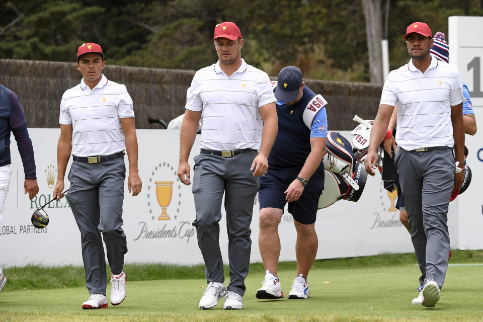 USA's Rickie Fowler, left, Bryson DeChambeau, center, and Tony Finau walk during a practice session ahead of the President's Cup Golf tournament in Melbourne, Tuesday, Dec. 10, 2019. (AP Photo/Andy Brownbill)