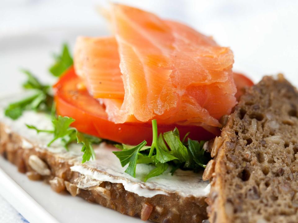 a salmon sandwich with arugula and tomato