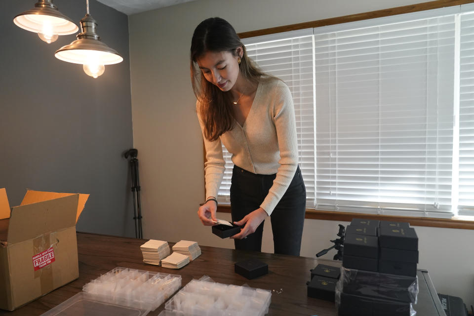 Hannah Nash places jewelry in a box that will be shipped out, Friday, Oct. 14, 2022, in Noblesville, Ind. Nash has her small business at her home. Small businesses are stocking the shelves early this holiday season and waiting to see how many gifts inflation-weary shoppers feel like giving. (AP Photo/Darron Cummings)