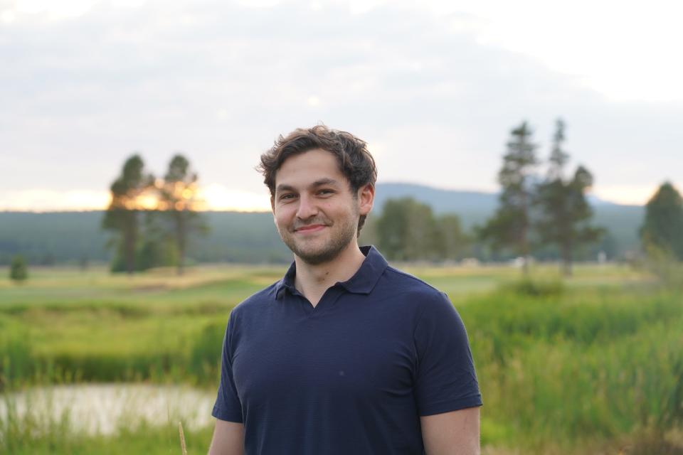 Justin Fineberg against a background of long green grass and trees.