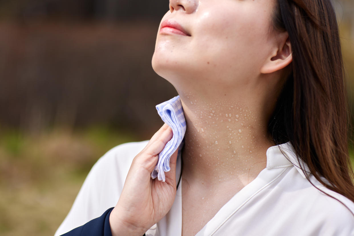 Sweat and hot Japanese woman, woman with sweaty neck holding towel