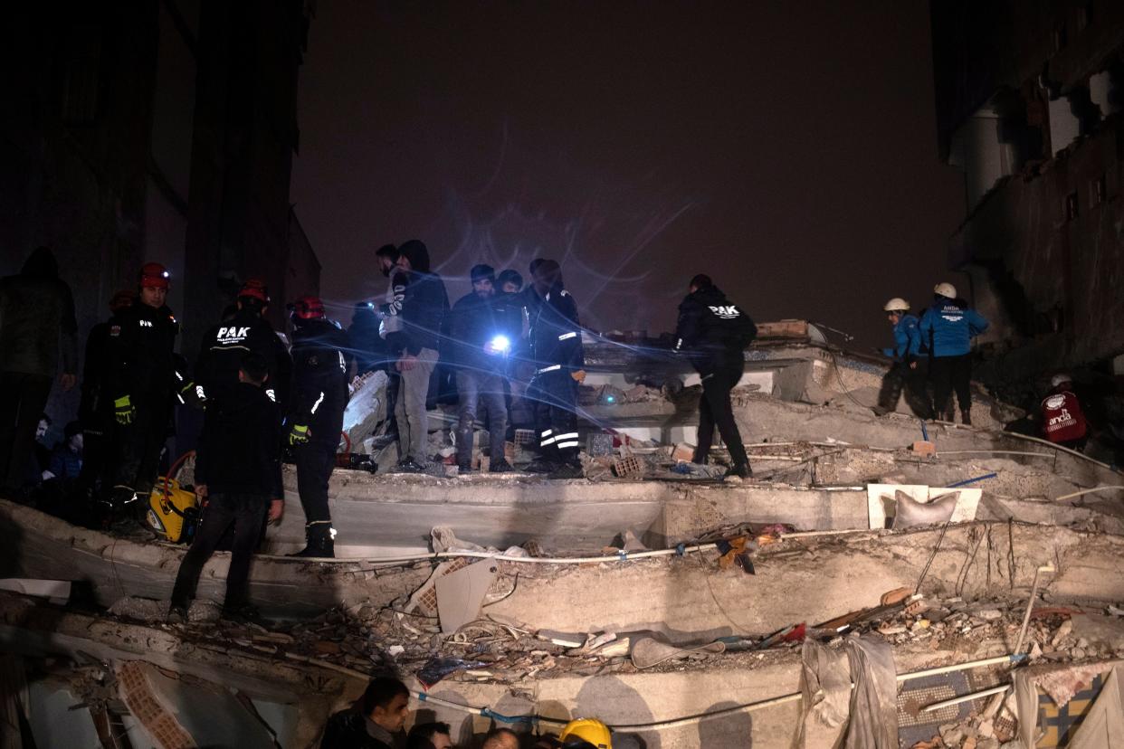 Turkish emergency personnel and others try to help victims at the site of a collapsed building (EPA)