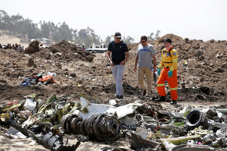 Israeli Moshe Briton (L) who's brother Daniel Reem, and Ilan Matsliah (C), who's brother Avi were on board of the flight ET 302, are accompanied by a volunteer of Israeli rescue and recovery organisation ZAKA as they search for remains of Ethiopian Airlines Flight ET 302 plane crash victims at the scene of a plane crash, near the town of Bishoftu, southeast of Addis Ababa, Ethiopia March 12, 2019. REUTERS/Baz Ratner