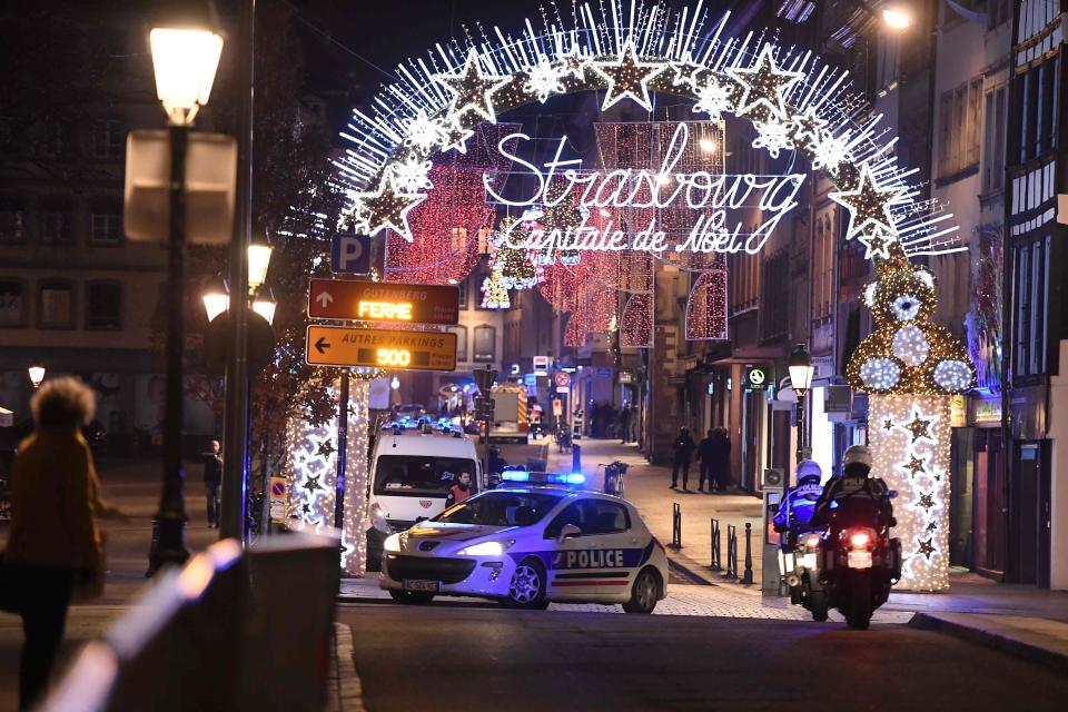 A police car is parked blocking traffic in the French city of Strasbourg after a gunman killed at least four people and wounded 11 others in a suspected terrorist attack, according to police union officials.