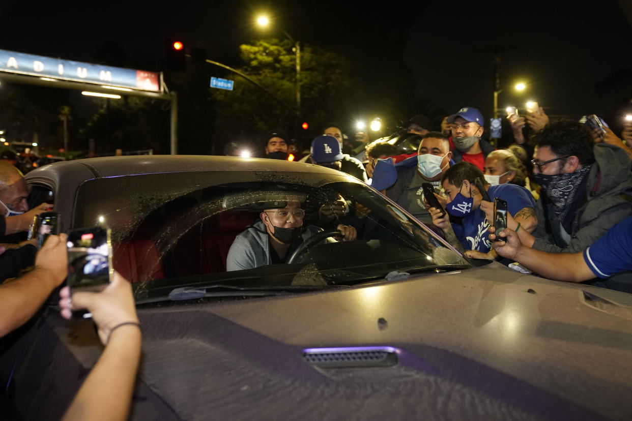 Julio Urías, pitcher de los Dodgers de Los Ángeles, se detuvo para saludar a los fanáticos al salir del Dodger Stadium en Los Ángeles. Foto: Damian Dovarganes / AP.