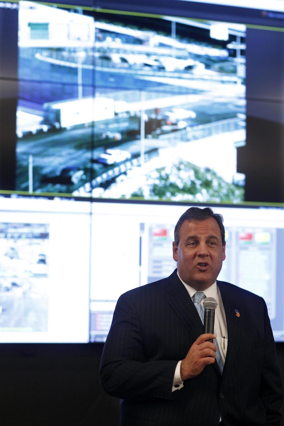 New Jersey Gov. Chris Christie speaks in front of large monitors as he visits the Super Bowl security operations center Wednesday, Jan. 29, 2014, in East Rutherford, N.J. (AP Photo/Mel Evans,pool)