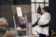 Laura Vásquez votó con su hija de un año cargada en brazos, en Houston, Texas, un estado dominado por los republicanos. El último demócrata que ganó en ese estado del sur fue Jimmy Carter en 1976, pero los expertos no descartaban sorpresas porque hasta hace unos días Trump lideraba sobre Biden por una ventaja mínima. (AP Photo/David J. Phillip) 