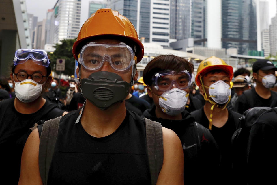 Protesters wearing protection gears march toward the Legislative Council as they continue to protest against the extradition bill in Hong Kong, Monday, June 17, 2019. Hong Kong police and protesters faced off Monday as authorities began trying to clear the streets of a few hundred who remained near the city government headquarters after massive demonstrations that stretched deep into the night before.(AP Photo/Vincent Yu)