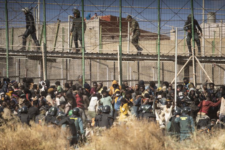 Agentes de la policía antidisturbios acordonan la zona tras la llegada de migrantes a suelo español y cruzar las vallas que separan el enclave español de Melilla de Marruecos en Melilla, España, el 24 de junio de 2022.