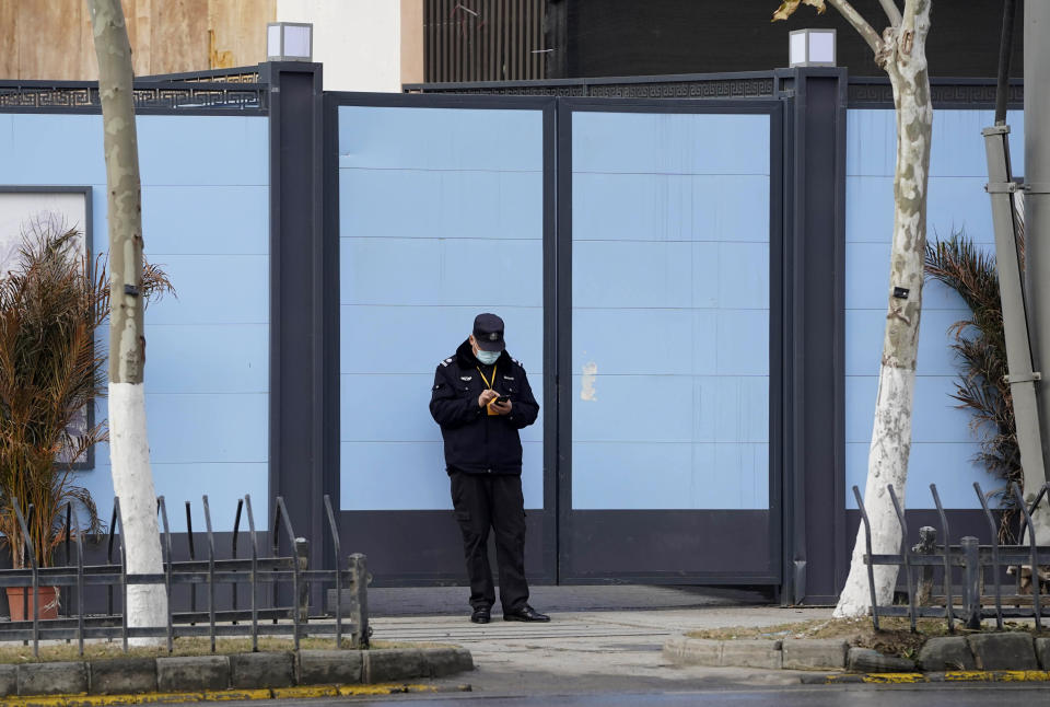 A security guard stands outside an entrance to the shutdown Huanan Seafood Market in Wuhan in central China's Hubei province on Friday, Jan. 15, 2021. Scientists initially suspected the coronavirus came from wild animals sold in the market. The market has since been largely ruled out but for the visiting WHO team of international researchers it could still provide hints to how the virus spread so widely. (AP Photo/Ng Han Guan)