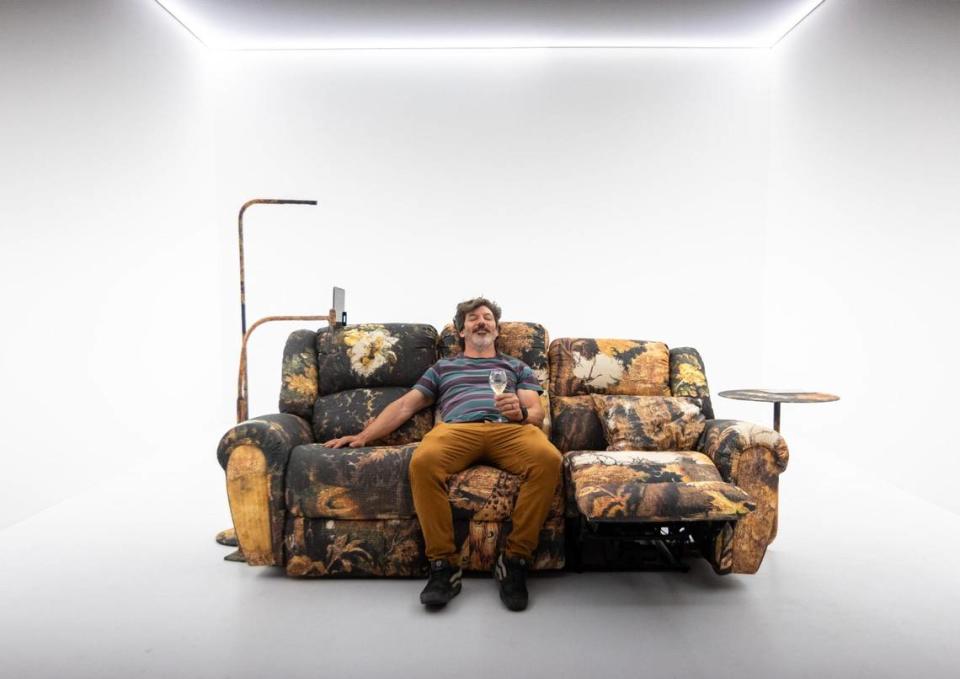 North Miami resident Robert Lorie, 41, sits on “Tapestry Sofa” by Harry Nuriev during the VIP opening of Design Miami for Art Basel in Miami Beach, Florida, on Tuesday, December 5, 2023.