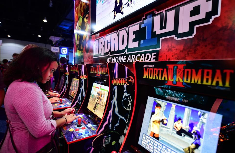 Woman plays video gabe Mortal Kombat II in an arcade