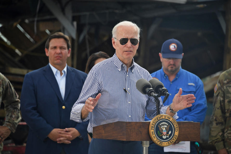 President Joe Biden speaks in a neighborhood impacted by Hurricane Ian in Fort Myers, Fla., on Oct. 5, 2022 as Florida Governor Ron DeSantis looks on.  (Olivier Douliery / AFP via Getty Images)