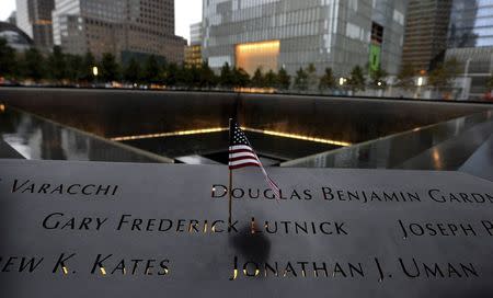 An American flag is seen placed in an inscribed name at the edge of the North Pool during memorial observances on the 13th anniversary of the 911 attacks at the site of the World Trade Center in New York, September 11 2014.REUTERS/Justin Lane/POOL