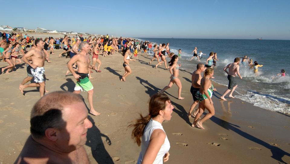 Participants in a previous Fenwick Freeze in Fenwick Island take the plunge.