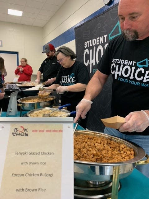 Chris Bolda, area director for food-service company Chartwells, serves up a sample portion of teriyaki-glazed chicken Wednesday at Centreville Jr./Sr. High School. Its students were asked to weigh in on potential new additions to their lunch menu.