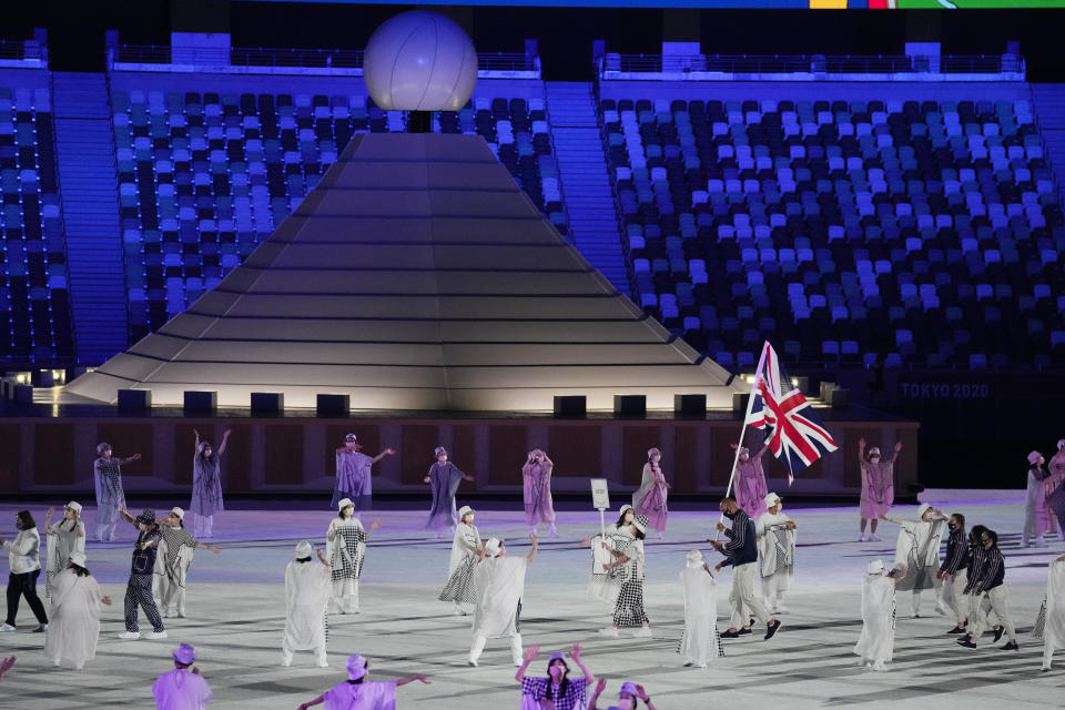 Hannah Mills y Mohamed Sbihi, de Gran Bretaña, portan la bandera de su país durante la ceremonia de inauguración de los Juegos Olímpicos de Tokio 2020 en el estadio olímpico el 23 de julio de 2021 en Tokio, Japón. (Foto AP/Kirsty Wigglesworth)