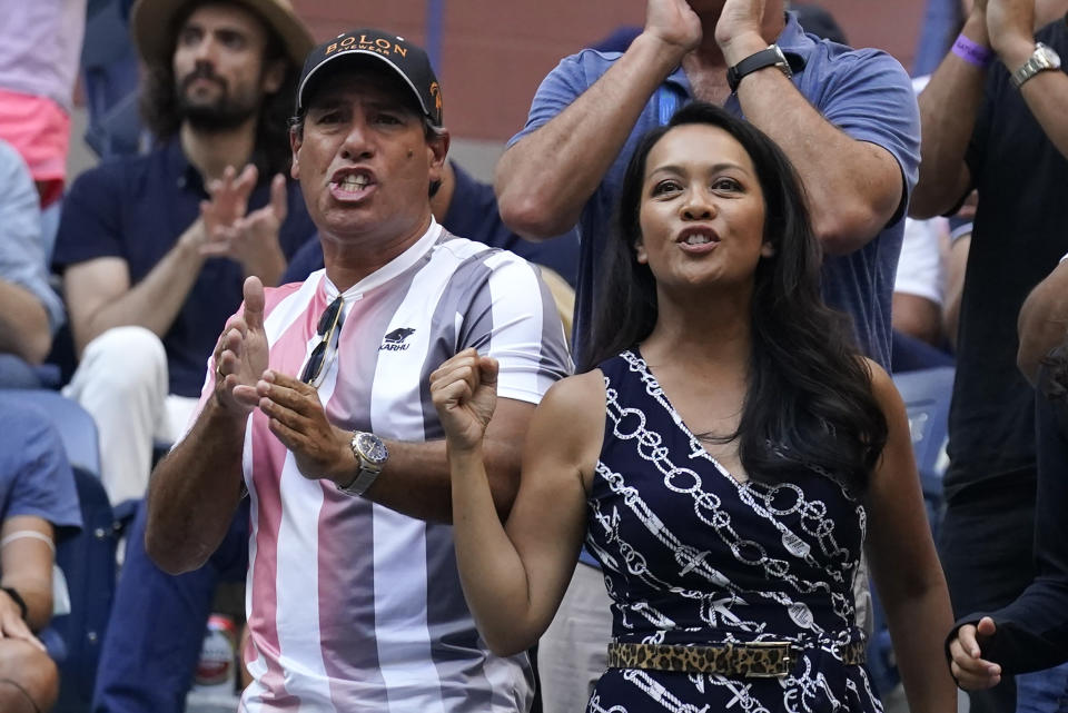 Duglas Cordero, left, fitness coach for Leylah Fernandez, of Canada, and Irene Exevea, Fernandez's mother, cheer her on during the women's singles final of the US Open tennis championships against Emma Raducanu, of Britain, Saturday, Sept. 11, 2021, in New York. (AP Photo/Seth Wenig)