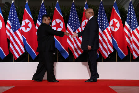 U.S. President Donald Trump shakes hands with North Korean leader Kim Jong Un at the Capella Hotel on Sentosa island in Singapore June 12, 2018. REUTERS/Jonathan Ernst