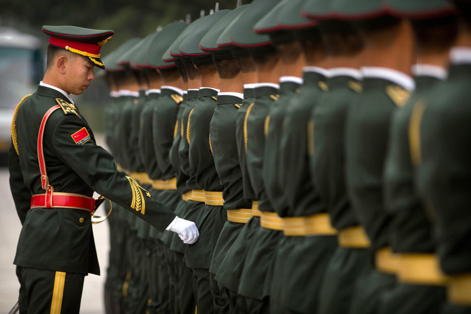 Adjusting a Chinese honor guard’s uniform in Bejing, China