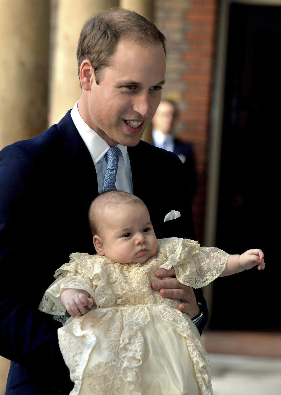 FILE - Britain's Prince William, holds his son Prince George as they arrive at Chapel Royal in St James's Palace in London, for the christening of the three month-old Prince Wednesday Oct. 23, 2013. The world watched as Prince William grew from a towheaded schoolboy to a dashing air-sea rescue pilot to a father of three. But as he turns 40 on Tuesday, June 21, 2022, William is making the biggest change yet: assuming an increasingly central role in the royal family as he prepares for his eventual accession to the throne. (John Stillwell/Pool Photo via AP, File)