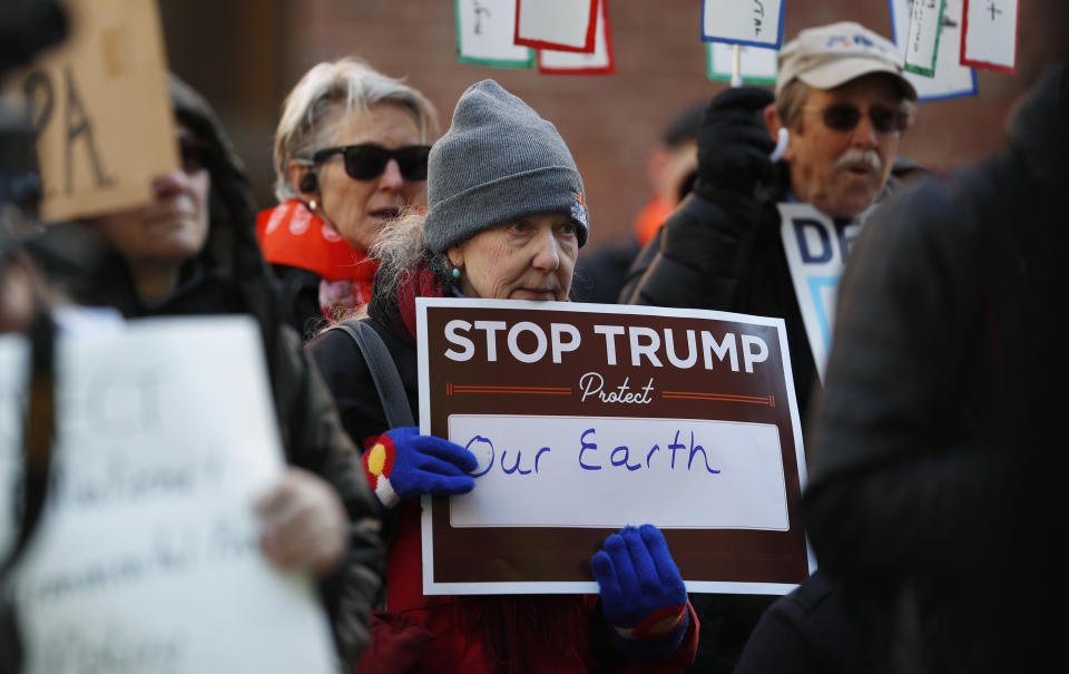 A protester holds a placard at a rally of advocates to voice opposition to efforts by the Trump administration to weaken the National Environmental Policy Act, which is the country's basic charter for protection of the outdoors on Tuesday, Feb. 11, 2020, in Denver. (AP Photo/David Zalubowski)