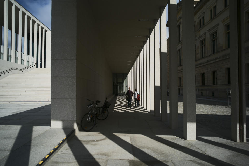 Two people walk to an entrance of the James-Simon-Galerie in Berlin, Germany, Wednesday, July 10, 2019. The James-Simon-Galerie is the new central entrance building for Berlin's historic Museums Island and will officially open on Friday, Jul 12, 2019. (AP Photo/Markus Schreiber)