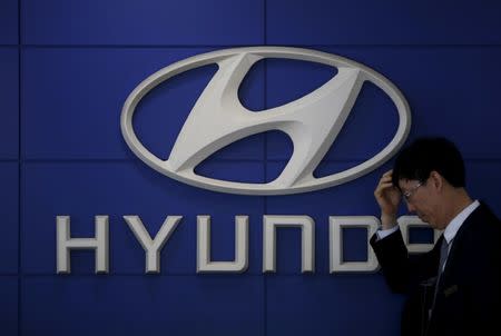 FILE PHOTO: A car dealer stands in front of the logo of Hyundai Motor at its dealership in Seoul, South Korea, April 25, 2016. REUTERS/Kim Hong-Ji/File Photo