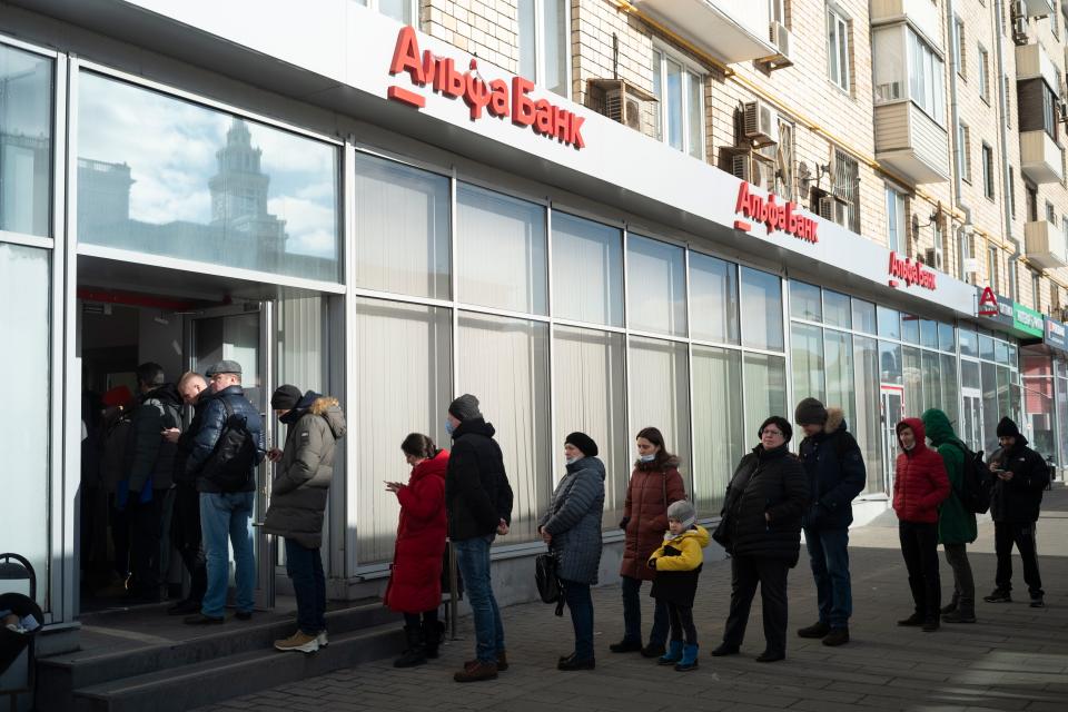People stand in line to withdraw money from an ATM of Alfa Bank in Moscow, Russia, Sunday, Feb. 27, 2022.