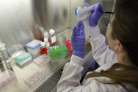 In this Wednesday, Jan. 15, 2020, photo, scientist and study director Jennifer Molignano notates the time she begins dosing living human skin tissues with two types of commercially available skin care products during a demonstration of experiments at a MatTek Corporation lab, in Ashland, Mass. MatTek is a tissue engineering company that performs non-animal testing on cosmetics, skin care products and pharmaceuticals. (AP Photo/Steven Senne)