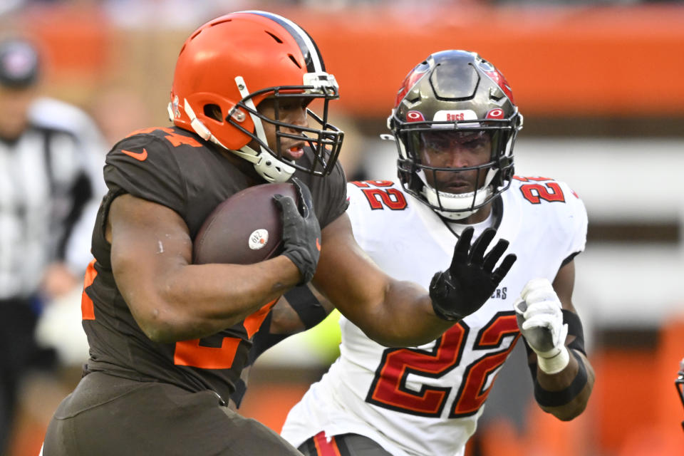 Cleveland Browns running back Nick Chubb, left, carries the ball with Tampa Bay Buccaneers safety Keanu Neal (22) on defense during the second half of an NFL football game in Cleveland, Sunday, Nov. 27, 2022. (AP Photo/David Richard)