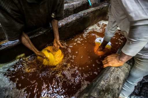 Workers dip the fabric in hot colour baths -- no gloves or masks protecting them from the dyes and chemical fumes