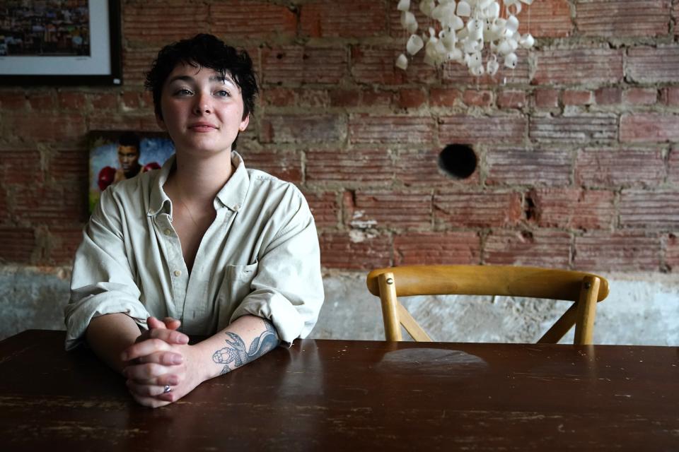 Melanie Rose Nipper, 28, an adjunct faculty member of Women’s Gender and Sexuality Studies at the University of Cincinnati, sits for a portrait, Tuesday, June 6, 2023, at Redtree Art Gallery and Coffee Shop in the Oakley neighborhood of Cincinnati.