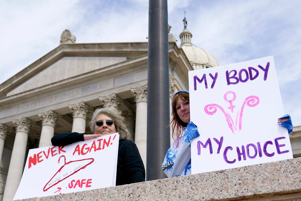 Dani Thayer, left, and Marina Lanae, right, both of Tulsa, Oklahoma, hold pro-choice signs at the state Capitol, Wednesday, April 13, 2022, in Oklahoma City.