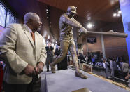 FILE- In this March 29, 2017, file photo, Hank Aaron looks at his new statue in Monument Garden at SunTrust Park, home of the Atlanta Braves, after the unveiling ceremony in Atlanta. Hank Aaron, who endured racist threats with stoic dignity during his pursuit of Babe Ruth but went on to break the career home run record in the pre-steroids era, died early Friday, Jan. 22, 2021. He was 86. The Atlanta Braves said Aaron died peacefully in his sleep. No cause of death was given. (Curtis Compton/Atlanta Journal-Constitution via AP, File)