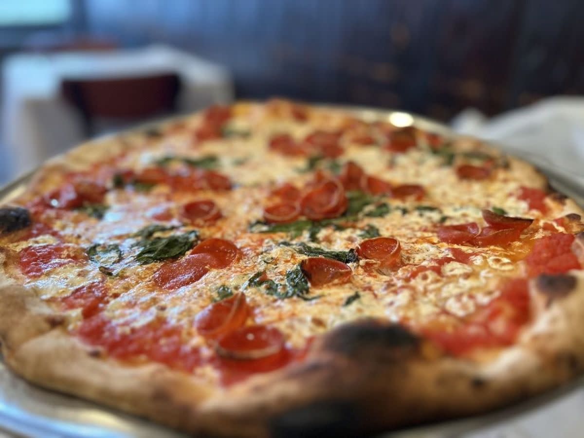 Patsy's Special Pizza in a pizza tray, Patsy’s Pizzeria, New York City, selective focus, seating in restaurant blurred in the background