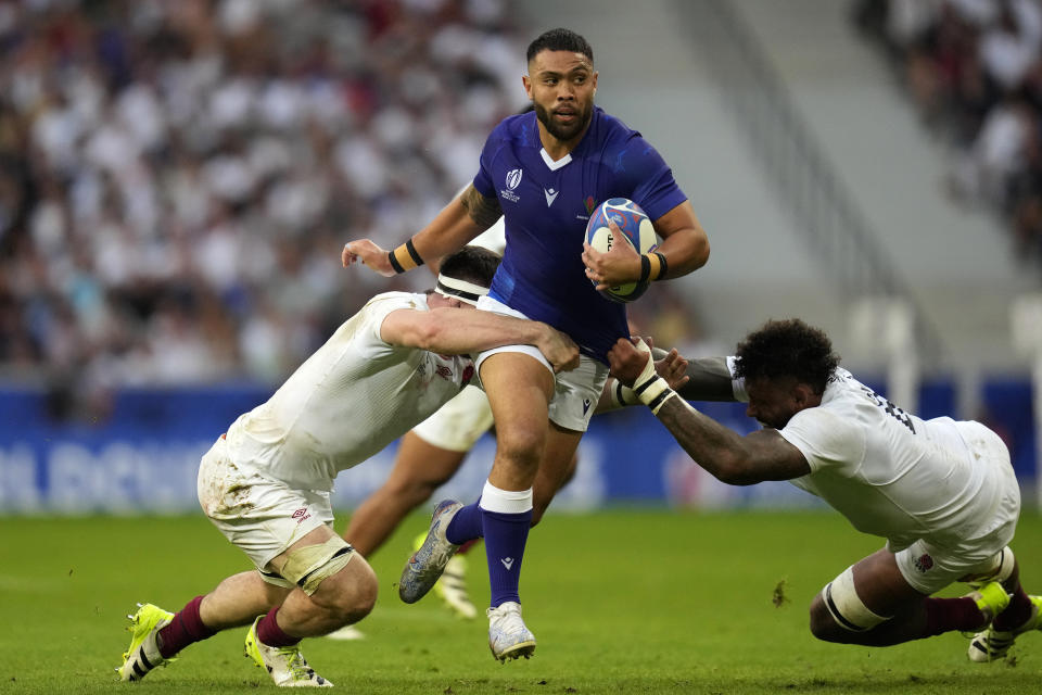 Samoa's Duncan Paia'aua, centre, is tackled by England's Tom Curry, left, and teammate Courtney Lawes during the Rugby World Cup Pool D match between England and Samoa at the Stade Pierre Mauroy in Villeneuve-d'Ascq, outside Lille, France, Saturday, Oct. 7, 2023. (AP Photo/Themba Hadebe)