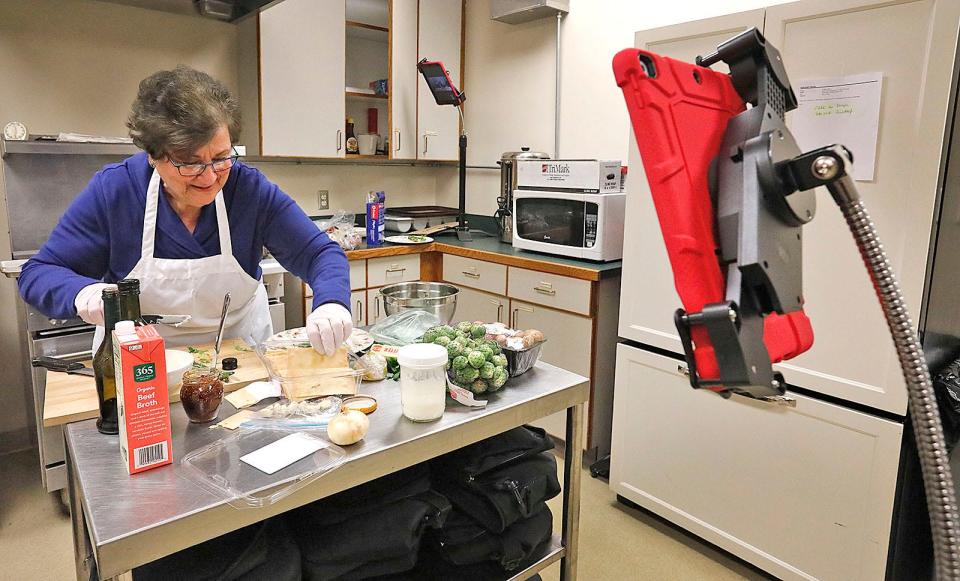 Joyce Bethoney of Hingham makes Christmas dinner in the Hingham senior center's kitchen as she is filmed by two iPads Thursday, Dec. 16, 2021.