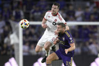 Toronto FC defender Kevin Long (5) and Orlando City forward Duncan McGuire (13) compete for the ball during the first half of an MLS soccer match Saturday, April 27, 2024, in Orlando, Fla. (AP Photo/Phelan M. Ebenhack)