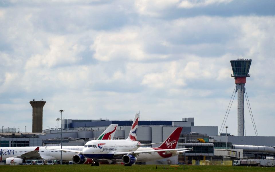  British Airways plane taxis past the control tower at Heathrow Airport. The airport and airlines are calling for the urgent reopening of transatlantic travel. - PA